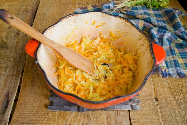 Cooking the vegetable mixture until soft and fragrant before adding the meat. A close-up of the softened vegetable mix simmering in the pot.