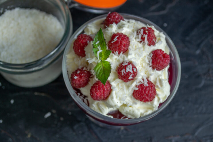Adding texture with coconut or nuts Shredded coconut being sprinkled over the raspberry jelly dessert.