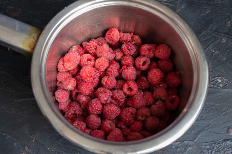 Step 1: Preparing fresh raspberries for the jelly Fresh raspberries being placed into a stainless steel heavy-bottomed pot.