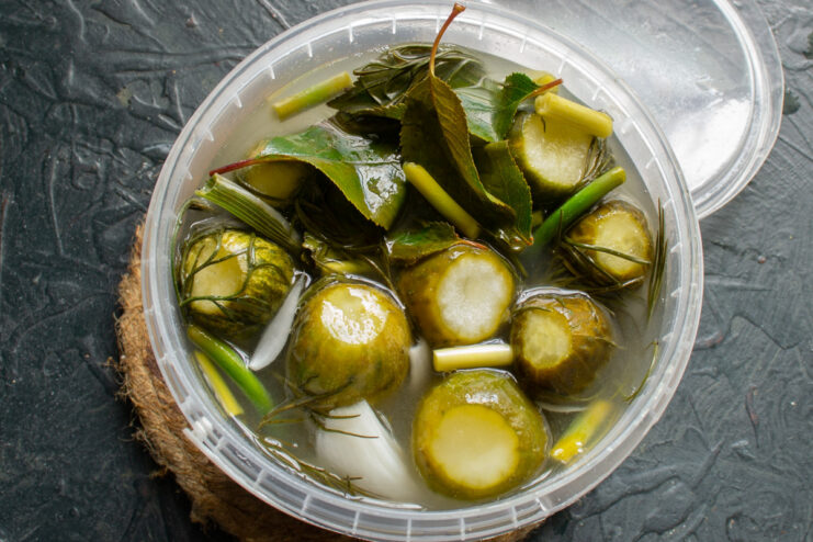 Letting the Cucumbers Ferment A covered container of cucumbers left on a countertop to ferment for a few days.