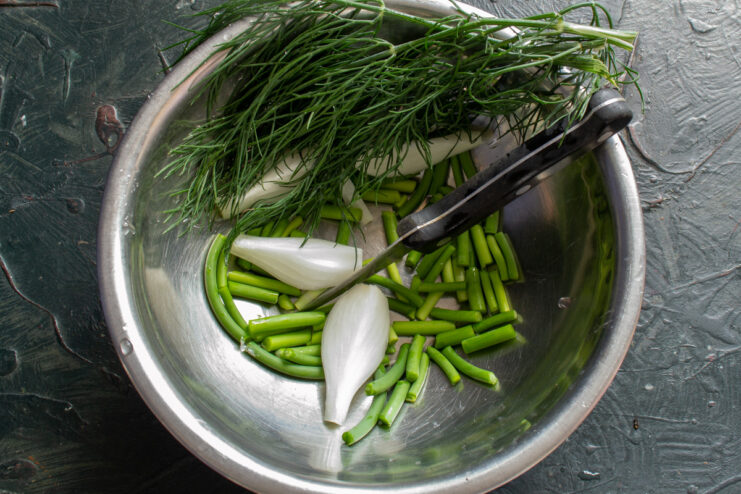 Washing Fresh Dill for the Brine A fresh bunch of dill being soaked in a bowl of clear water.