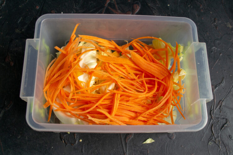 Julienned carrots being prepared with a special grater for Korean-style salads.
