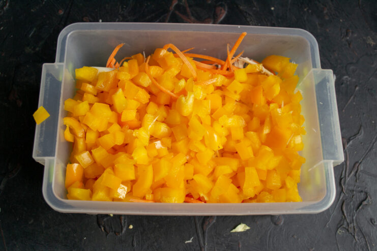 Diced yellow bell pepper in a pile on a cutting board.