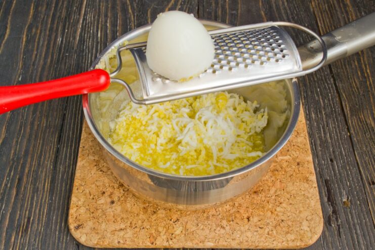 Creating the Rich Texture of Polish Sauce with Eggs Finely chopped hard-boiled eggs being added to melted butter in a saucepan.