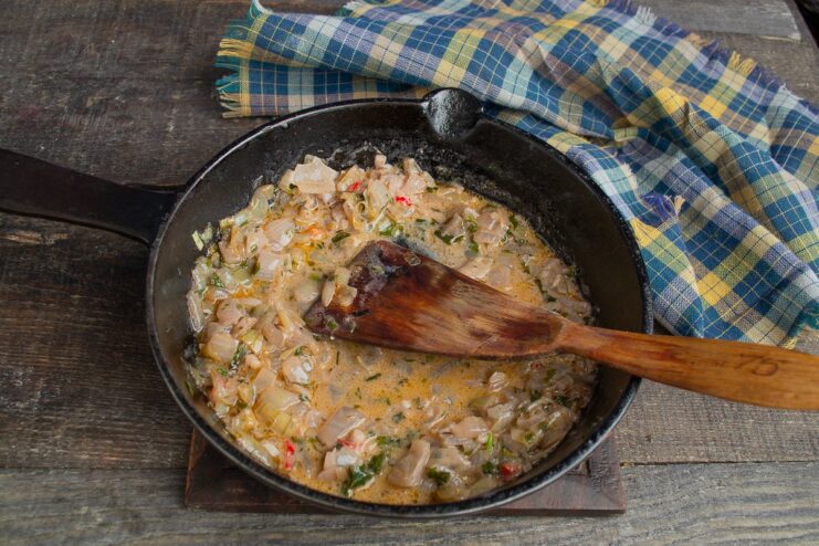 Sautéing vegetables in a pan to create the base for a creamy Provençal sauce.