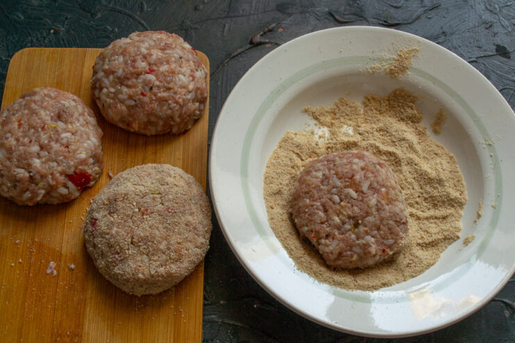 Preparing the Breadcrumb Coating A plate with a pile of breadcrumbs ready for coating the patties.
