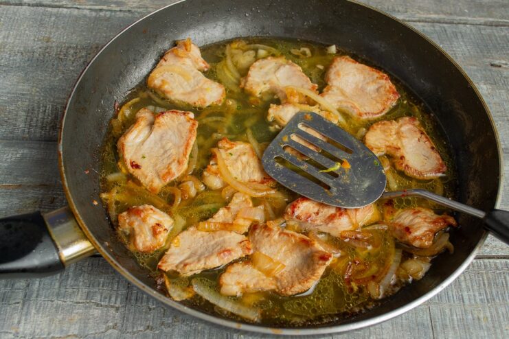 Deglazing the Pan with Hot Chicken Broth Hot chicken broth being poured into the skillet to deglaze it.