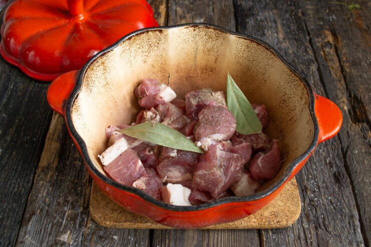 Placing Marinated Pork in a Pot to Start the Cooking Process Marinated pork in a pot with water, being brought to a boil.