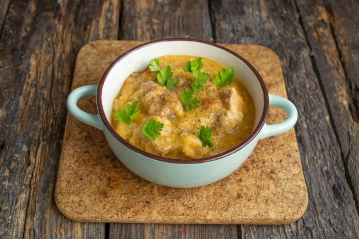The Finished Portuguese Pork Stew, Ready to Be Served A bowl of the finished Portuguese pork and lentil stew, garnished with fresh herbs.