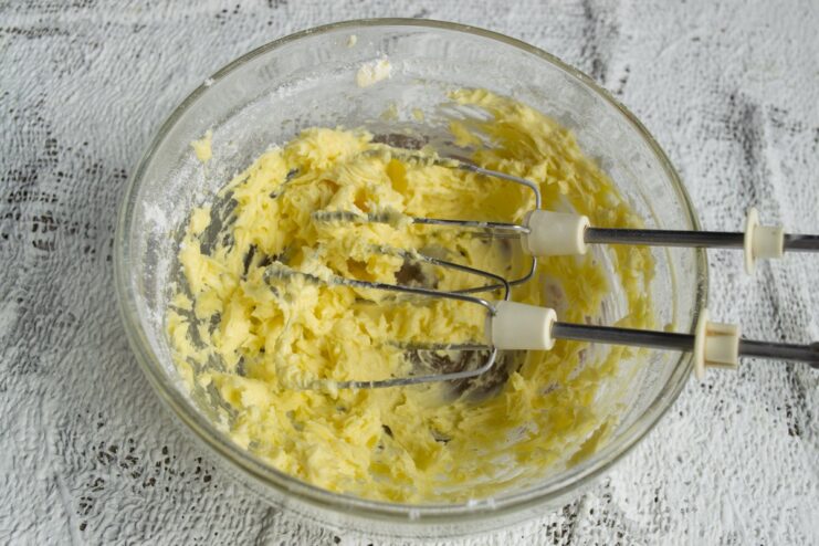 Creaming butter and sugar is the first step to tender cookies. See how to get the perfect fluffy texture. A mixing bowl with creamed butter, powdered sugar, and an egg being mixed together.