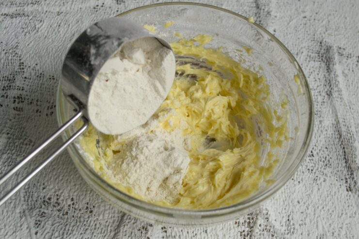 Combining wet and dry ingredients to form the cookie dough. Chilling is a crucial step! Mixing flour into the wet ingredients to form a soft cookie dough in a bowl.