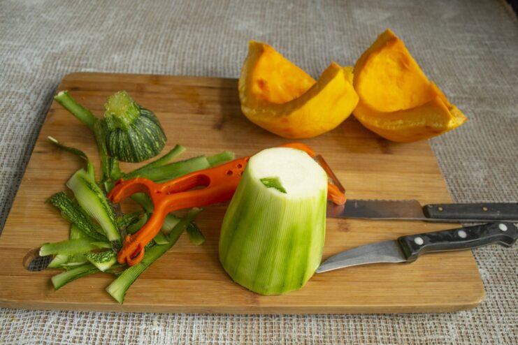 How to prepare zucchini: peeling and removing the soft core. Peeled and halved zucchini with the seeds scooped out.