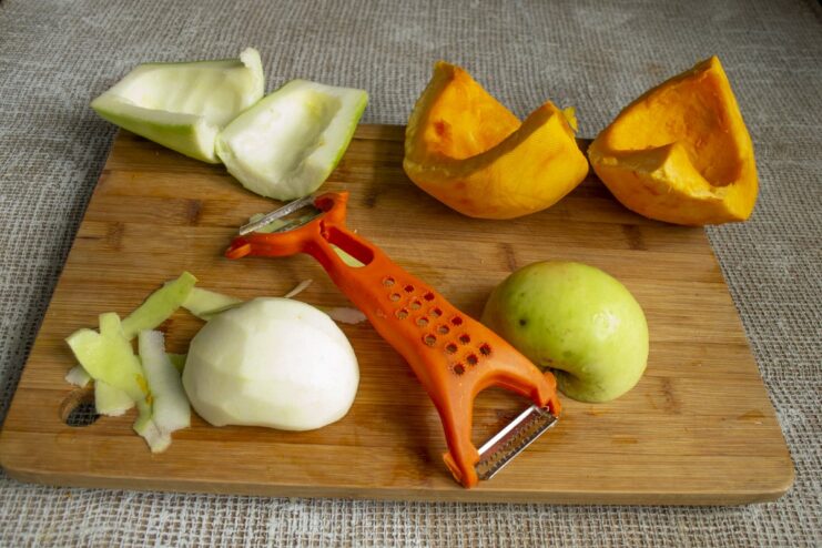 Preparing apples for the purée by removing the skin and core. Peeled and cored apple halves ready for slicing.