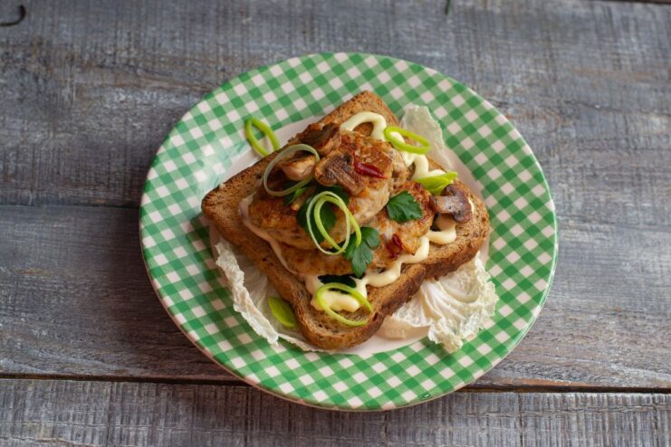 Serving Suggestion: Chicken Kotlety on Toast with Sauce and Greens A final dish of chicken kotlety served on toast with sauce and fresh herbs.
