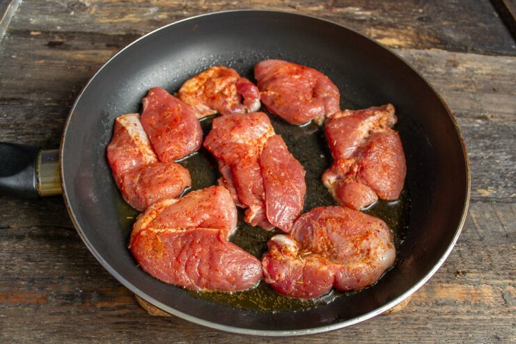 Step 4: Frying the Pork Cutlets Pork cutlets sizzling in a hot frying pan with plenty of space between them.