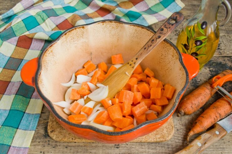Sautéing Carrots and Onions: Building the Flavor Base for Plov Carrots and onions being fried in a Dutch oven over high heat.
