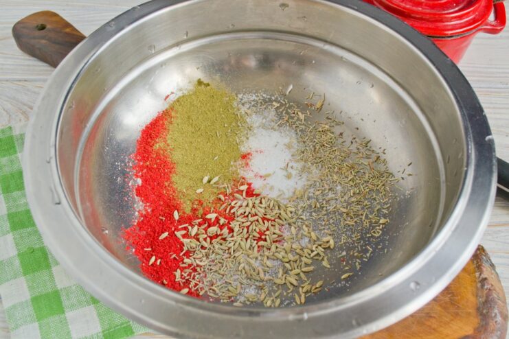 A blend of paprika, caraway, and fennel for a flavorful pork rub. A small bowl with a mix of red and brown spices and salt.