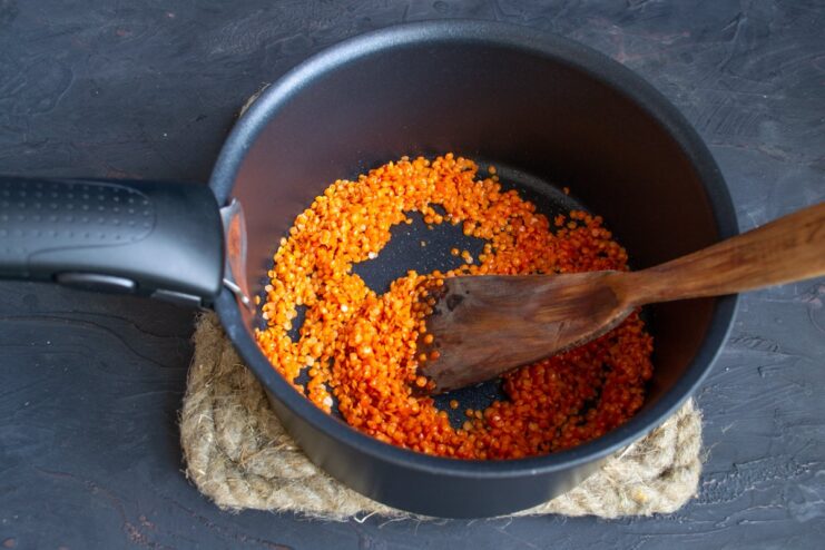 Quickly sautéing lentils brings out their flavor Red lentils being sautéed in a saucepan with olive oil.