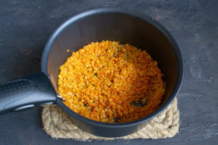 Cooking lentils until they are tender but still whole Lentils simmering in water in a saucepan on the stove.