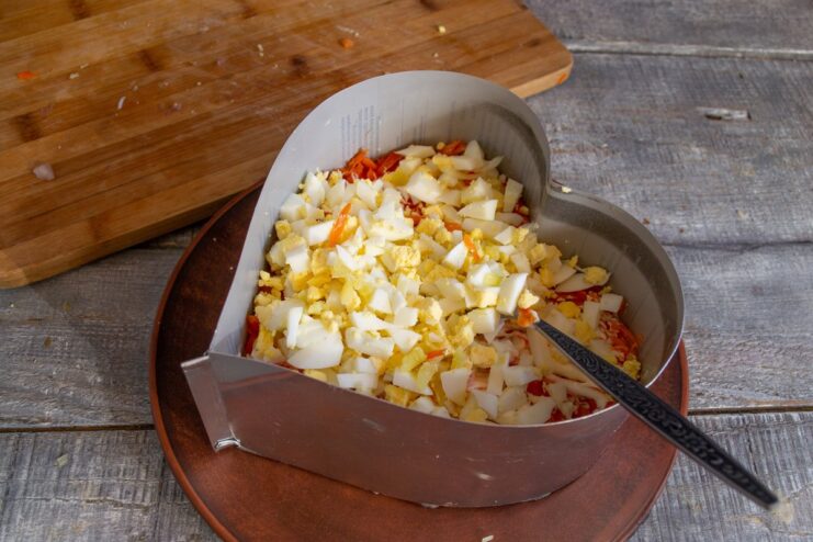 Step 5: The Diced Egg and Mayonnaise Layer Diced hard-boiled eggs layered in the salad, generously covered with mayonnaise.