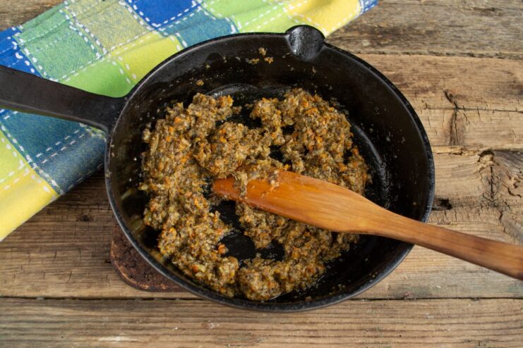 Sautéing Mushroom Pâté in a Pan with Butter Mushroom pâté being heated in a skillet with a pat of butter.