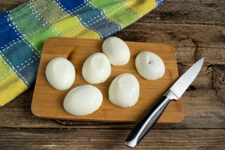 Halved Hard-Boiled Eggs Ready for Stuffing Halved hard-boiled eggs with yolks removed, ready to be filled.