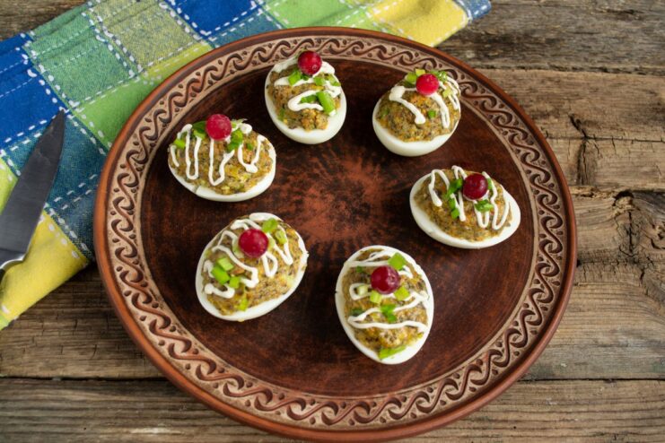 Final Touches: Garnishing Deviled Eggs with Cranberries and Onions The finished egg appetizer with mushroom pâté, garnished with fresh cranberries and chopped green onions.