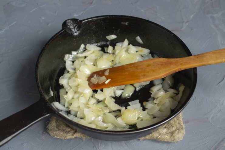 Step 3: Sautéing onions until golden Chopped onions being sautéed in a pan with butter.