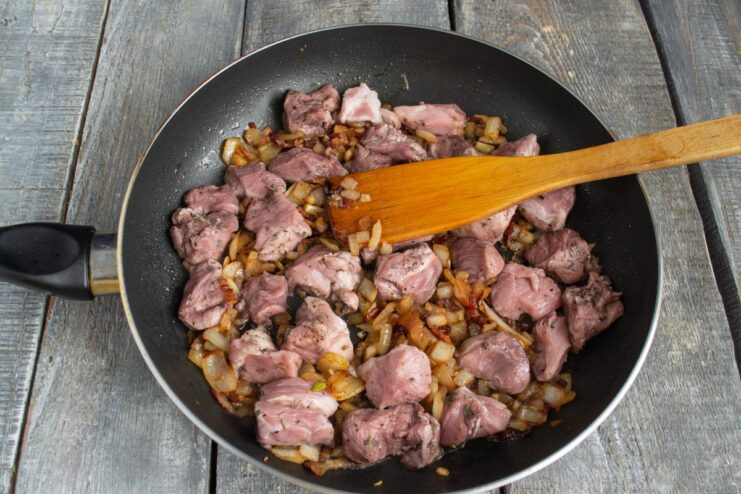 Searing Marinated Pork to Lock in Juices Marinated pork cubes being seared in a hot pan until browned on all sides.