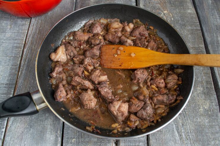 Deglazing the Pan with Wine Marinade for a Rich Sauce Reducing the red wine marinade in the pan with the seared pork and vegetables.