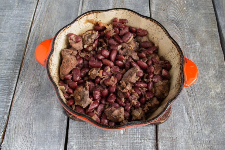 Simmering the Stew to Perfection The complete pork and bean stew simmering gently in a Dutch oven on the stove.