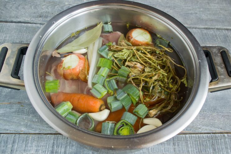 Starting the Chicken Broth with Cold Water A pot with chicken and vegetables being filled with cold water.