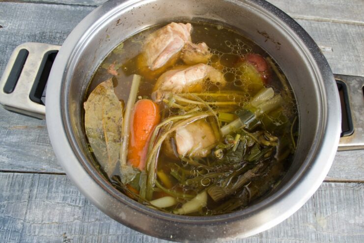 How to Simmer the Perfect Chicken Broth Chicken broth simmering gently in a pot on the stove.