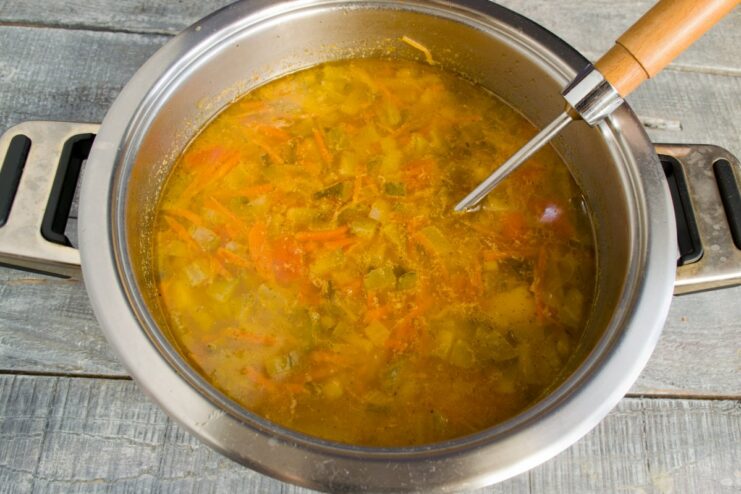 Simmering the Rassolnik to Meld Flavors The Rassolnik soup simmering in a large pot with all vegetables and broth.