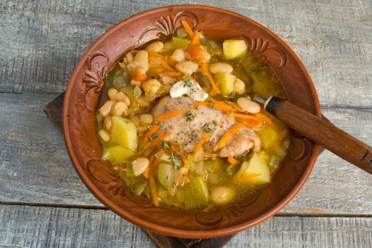 The Finished Rassolnik - Ready to Serve! A serving of hot Rassolnik with chicken and beans in a white bowl, ready to eat.