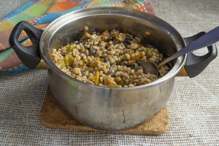 Letting the cooked barley rest off the heat to become perfectly fluffy. A covered pot of cooked pearl barley resting to steam.