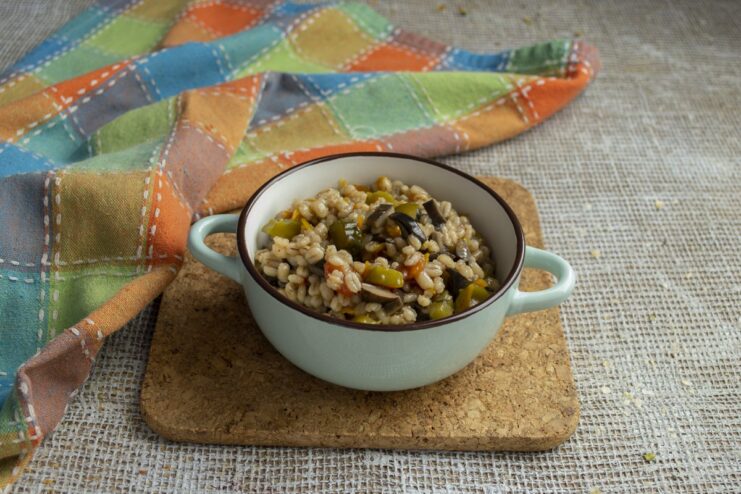 The finished dish: perfectly cooked, fluffy pearl barley ready to be served. The finished fluffy pearl barley with mushrooms and pickles in the pot, ready to serve.