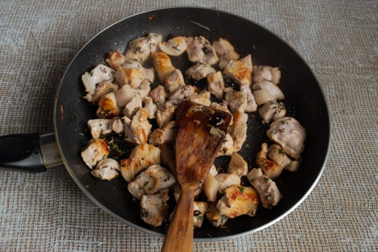Browning the Meat Perfectly for a Rich and Savory Plov Golden-brown pieces of meat seasoned with thyme frying in a pan.