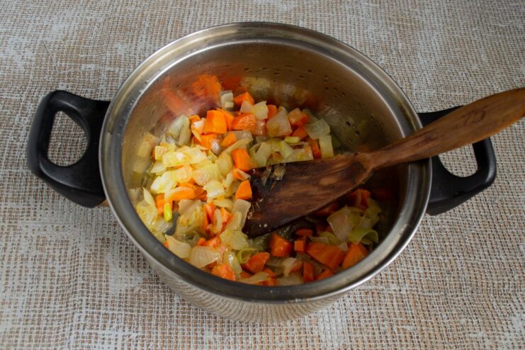 Assembling the Plov: The First Layer of Sautéed Vegetables A layer of sautéed onions and carrots at the bottom of a heavy pot (kazan).