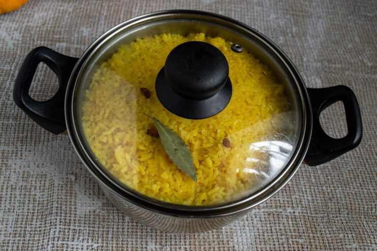 Simmering to Perfection: The Final Stage of Cooking Plov A pot of plov covered with a lid, simmering on low heat to meld the flavors.
