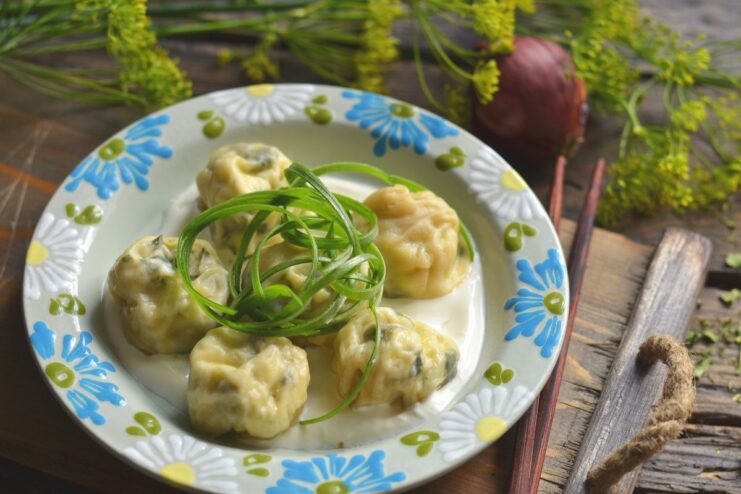 A plate of freshly made vegetarian ravioli, garnished with herbs.