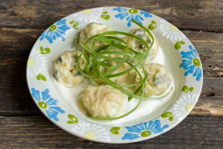 Ready to Serve: Delicious Homemade Ravioli with Fresh Herbs A finished plate of steamed ravioli garnished with fresh green herbs.