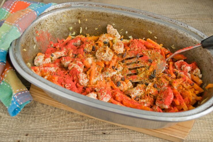 Sprinkling in the aromatic spices for the signature plov flavor. A hand adding a blend of plov spices to the meat and vegetables in the pot.