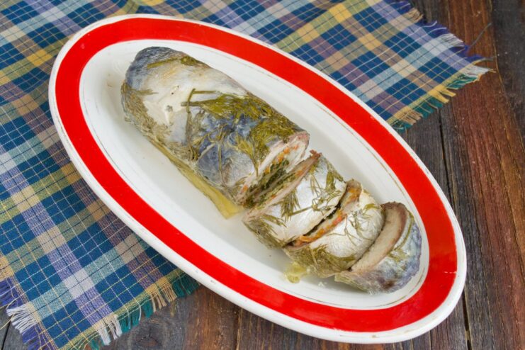 Slicing the Chilled Mackerel Roulade for Serving The finished mackerel roulade being sliced, revealing the beautiful layered interior.