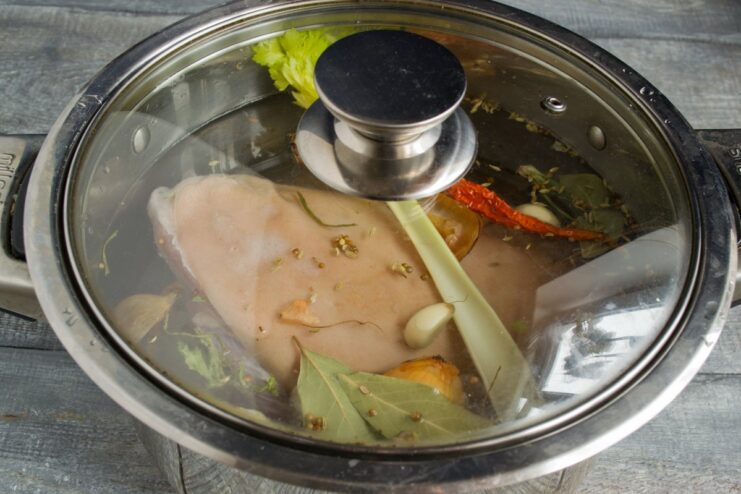 The Pork Knuckle Simmering Gently on the Stove A large pot on a stove, with the pork knuckle simmering in a flavorful broth.
