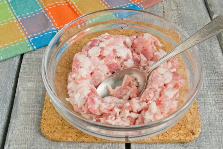 Preparing the Ground Pork for Patties Chilled ground pork in a white mixing bowl.