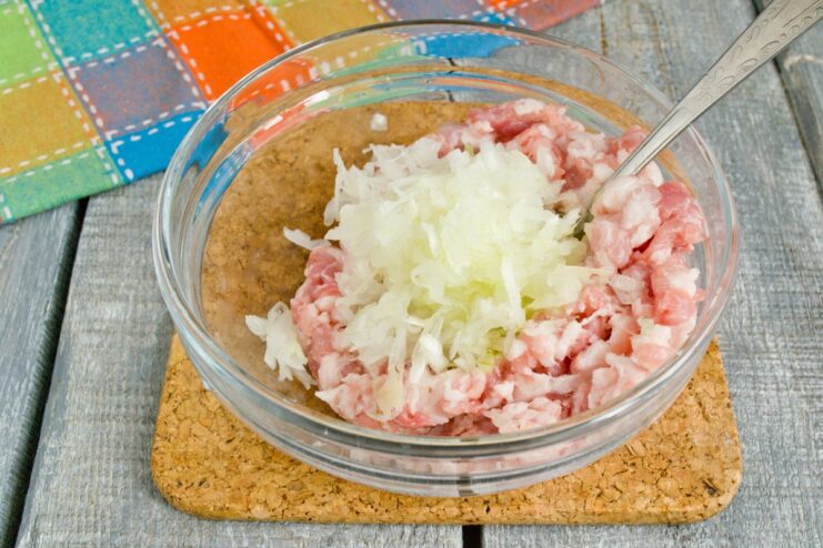 Finely Grated Onion for Maximum Flavor Onion being grated on a box grater for the patty mixture.