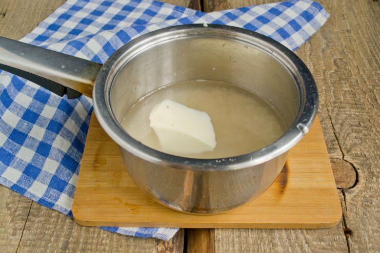 Parboiled rice cooking in a pot with butter A pot of white rice being cooked for the plov.