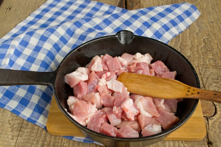 Searing diced meat for the Shah Plov filling Cubes of meat browning in a hot skillet.