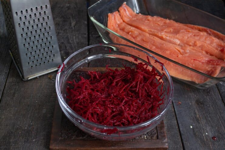 Preparing the Beetroot Cure for Gravlax Fresh beetroot being finely grated into a bowl for the gravlax cure.